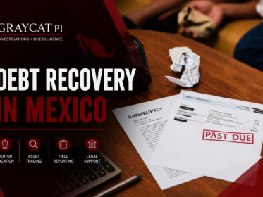 GrayCat PI blog cover image for a debt recovery article, showing a dark maroon banner over a real photo of past-due documents on a wooden table, with the text “Debt Recovery in Mexico” and service icons for debtor location, asset tracing, field reporting, and legal support.
